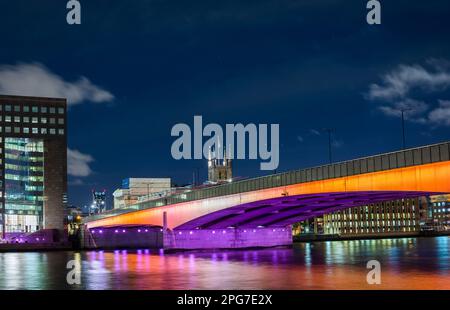 Die in Orange und Lila beleuchtete London Bridge ist Teil der beleuchteten River Art Installation auf der Themse des Künstlers Leo Villareal. Stockfoto