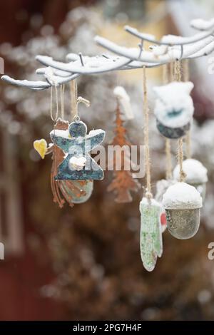 Eine Winterszene mit einem Charismas-Baum, geschmückt mit festlichen Ornamenten, an einem verschneiten Wintertag Stockfoto