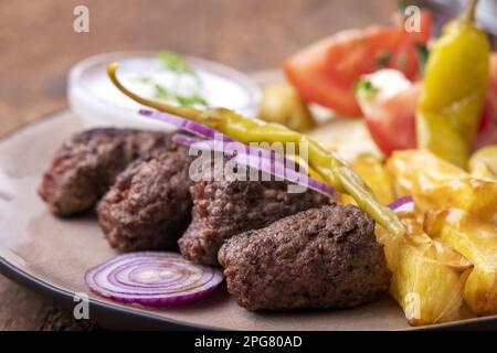 Cevapcici auf Einem Teller mit Pommes frites Stockfoto