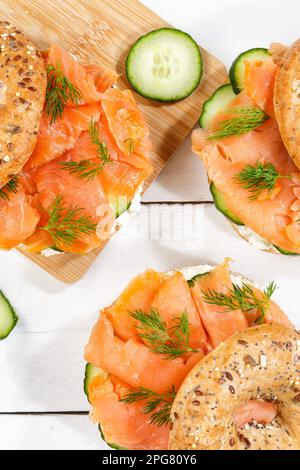 Stuttgart, Deutschland - 15. März 2023: Bagel Roll Sandwich zum Frühstück garniert mit Lachsfischen von oben auf Einem Holzbrett Portrait in Stuttgart, Deutsch Stockfoto