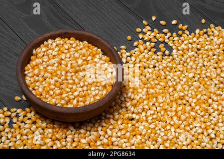 Nahaufnahme einer Schüssel mit Maiskernen auf einem Holztisch Stockfoto
