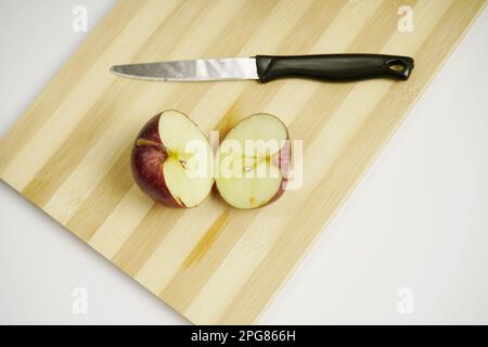 Draufsicht auf Apfelscheiben mit Messer auf dem Schneidebrett Stockfoto
