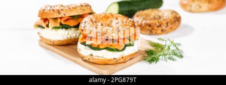 Stuttgart, Deutschland - 15. März 2023: Bagel Roll Sandwich zum Frühstück gekrönt mit Lachsfisch auf einem Brett Panorama in Stuttgart. Stockfoto