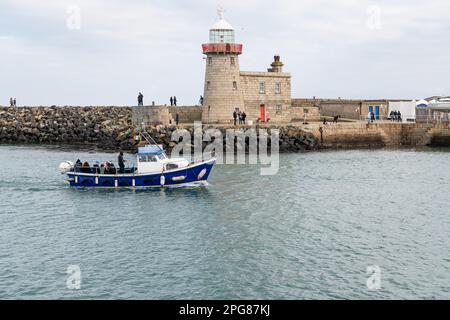 Pinalia - Ireland's Eye Ferry, vorbei am Leuchtturm auf dem East Pier, Einfahrt in den Hafen, Howth, Dublin, Irland Stockfoto