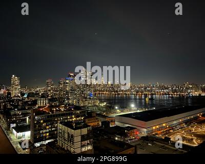 Ein atemberaubender Blick aus der Vogelperspektive auf die große Skyline der Stadt, die bei Nacht mit hellen Lichtern beleuchtet wird Stockfoto