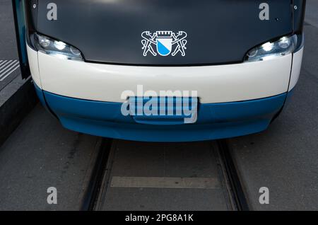 Zürich, Schweiz - 22. Februar 2023: Die Vorderseite einer modernen weiß-blauen Straßenbahn in Zürich mit dem Wappen der Stadt Zürich Stockfoto