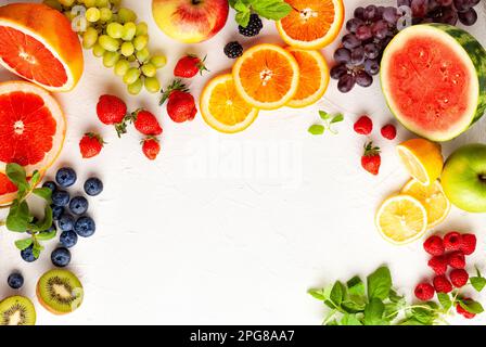 Verschiedene frische Früchte und Beeren auf weißem Hintergrund. Saubere Ernährung, gesundes Leben. Draufsicht. Stockfoto