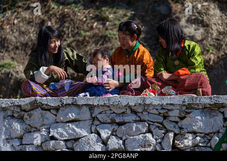 JAKAR, BHUTAN - 1. JANUAR 2017: Frauen in einer Kleinstadt im Osten Bhutans beobachten während eines lokalen Tsechu Festivals Schauspieler. Tsechu sind jährlich Stockfoto