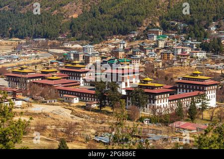 Tashichho Dzong aus der Vogelperspektive mit der Stadt Thimphu im Hintergrund. Stockfoto