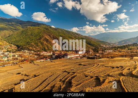 Tashichho Dzong aus der Vogelperspektive mit der Stadt Thimphu im Hintergrund. Stockfoto