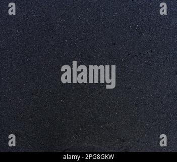 Abstrakter Texturhintergrund aus kleinen schwarzen Sandpartikeln. Stockfoto