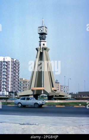 Abu Dhabi VAE 1976 – Uhrenturm im Kreisverkehr am nördlichen Ende der Airport Road (jetzt Sheikh Rashid bin Saeed Street) in Abu Dhabi, Vereinigte Arabische Emirate Stockfoto