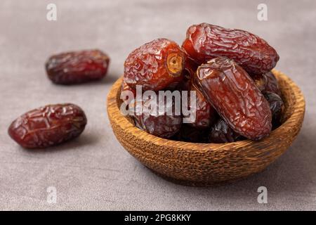 Köstliche getrocknete Datteln in einer Holzschüssel. Stockfoto
