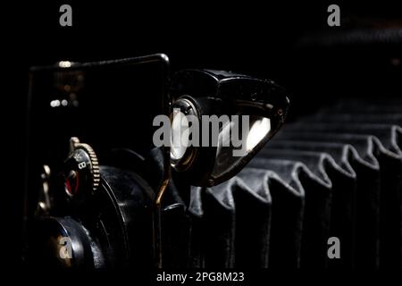 Details einer klassischen analogen Faltenbalgkamera mit schwarzem Hintergrund Stockfoto