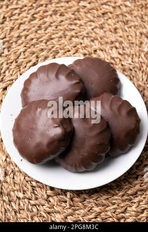 Foto-Marshmallow in Schokolade auf einem weißen Teller Stockfoto