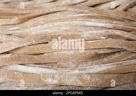 Ungekochtes hausgemachtes Soba (Buchweizennudeln) als Hintergrund, Nahaufnahme Stockfoto