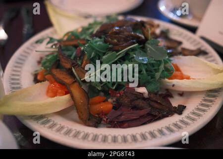 Eine Nahaufnahme eines Tellers gefüllt mit einer Vielzahl von gekochtem Fleisch und Gemüse, kunstvoll arrangiert Stockfoto