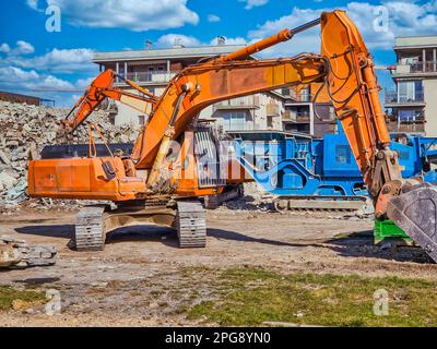 Orangefarbener Bagger auf der Baustelle Stockfoto