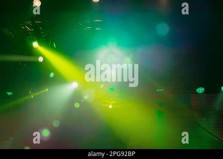 Punktstrahler, lebendige mehrfarbige Laserstrahlen, Nebel und Bokeh Stockfoto