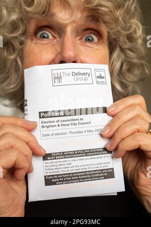 Eine Frau mit ihrem Wahlausweis, bei dem ein Lichtbildausweis erforderlich ist, um bei den bevorstehenden kommunalwahlen im Vereinigten Königreich wählen zu können Stockfoto