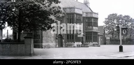 1950er, historisch, Fassade des Red Lion Public House, ein elegantes altes Gebäude in Vicarage Rd, Kings Heath, Birmingham, England, Großbritannien. Draußen steht ein Schild mit der Aufschrift "Ye Olde Red Lion". Zu dieser Zeit war es ein lizenziertes Gelände von Mitchells & Butlers. Der Pub wurde 1904 von der Priory Estate Co als „verbesserter Pub“ erbaut, um ein neues Wohnhaus zu bedienen. Das Konzept besteht darin, „Olde Englishe“ Tavernen nachzubilden und sich von viktorianischen Gin-Palästen zu entfernen. Architektonisch wurde das Gebäude von der Arts & Crafts-Bewegung beeinflusst und basiert auf dem Angel and Royal in Grantham in Lincolnshire. Stockfoto