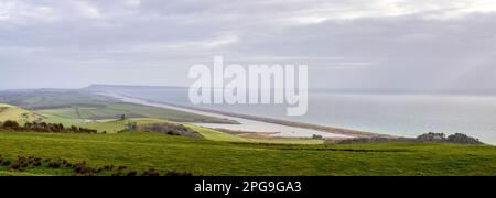 Jurassic Coast Chesil Beach und die Fleet Lagoon mit der Isle of Portland im Hintergrund und der St. Catherine's Chapel Abbotsbury im Mittelgrund Stockfoto