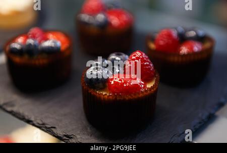 Köstliche Cupcakes mit Erdbeeren und Blaubeeren, zubereitet zum Mittagessen in einem Gebäckcafé Stockfoto