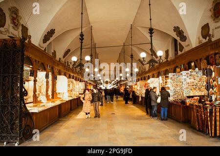 Krakau, Polen - 6. märz 2023: Touristen kaufen Souvenirs in der berühmten Touristenattraktion Stoffmarkt Stockfoto