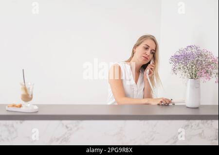 Rezeptionistin in einem Schönheitssalon, die mit einem Kunden telefoniert. Stockfoto