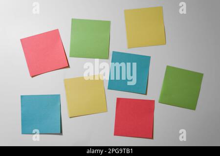 Sammlung von farbigen, leeren Haftnotizen auf weißem Hintergrund. Leere Haftnotizen. Modell-Haftnotiz-Papier. Blaue, rote, grüne und gelbe Aufkleber. Stockfoto
