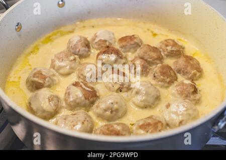 Süße Fleischbällchen in einer cremigen weißen Sauce. Fleischbällchen schließen sich einer Bratpfanne Stockfoto