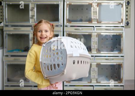 Porträt eines kleinen Mädchens, das Käfig hält, mit neuem Haustier, das im Tierarzt gekauft wurde Stockfoto