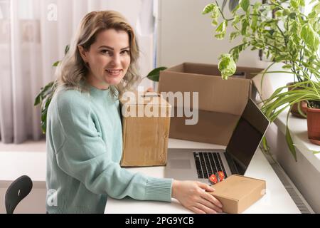 Nahaufnahme eines weiblichen Online-Shops, Inhaber eines kleinen Unternehmens, Unternehmer, der Verpackungspakete nach dem Versand vorbereiteter Versandkarton auf dem Tisch vorbereitet Stockfoto