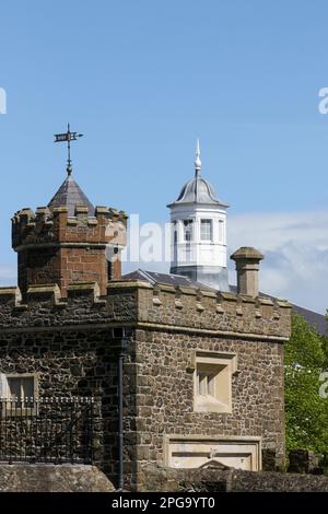 Alte historische Gebäude in Antrim, die Barbican Gate Lodge und Zinnen mit dem Old Courthouse Tower im Hintergrund. Altstadt Antrim. Stockfoto