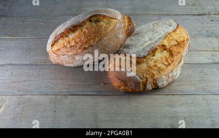 Knuspriges hausgemachtes Brot auf Holzbrett aus Hefe und organischem, weißem, starkem Mehl, Joghurt, Honig und Wasser. Stockfoto