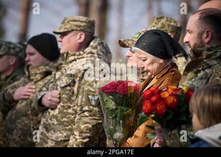 Moschun, Ukraine. 21. März 2023. Ukrainische Bürger nehmen am 21. März 2023 an der Eröffnungszeremonie für die neu enthüllte Gedenkstätte der Engel des Sieges zu Ehren der Verteidiger der Hauptstadt in Moschun, Oblast Kiew, Ukraine Teil. Kredit: Pool Photo/Pressestelle Des Ukrainischen Präsidenten/Alamy Live News Stockfoto