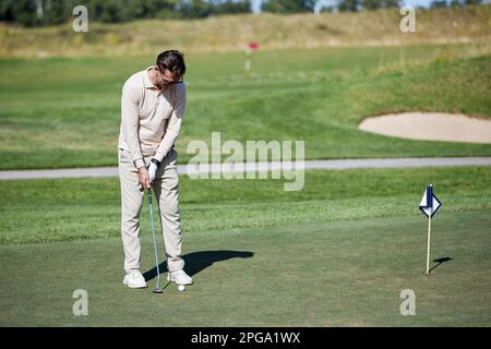 Porträt eines erwachsenen weißen Mannes, der Golf auf grünem Gras spielt, Kopierbereich Stockfoto