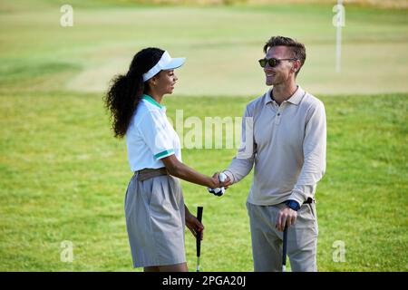Porträt von zwei Golfspielern, die sich nach einem Spiel die Hände schütteln Stockfoto