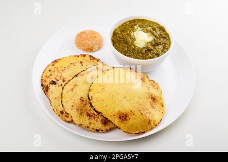 Saag mit Makki roti auf Platte auf weißem Hintergrund Stockfoto