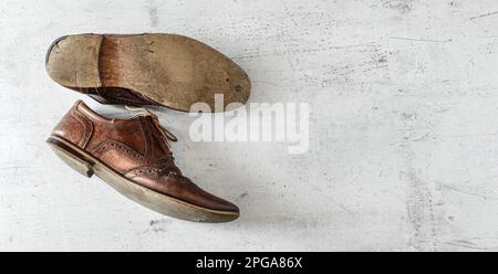 Blick von oben nach unten, klassische dunkelbraune Schuhe mit Lochmuster auf dem Whiteboard. Breites Banner mit Platz für Text rechts Stockfoto
