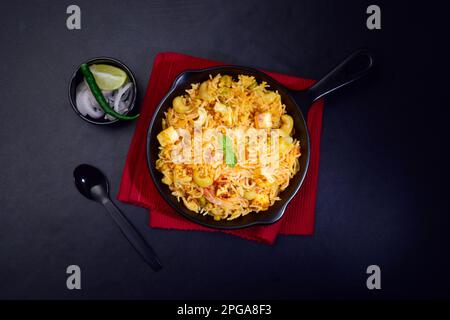 Blick von oben auf Paneer Pulao serviert mit Zwiebeln und Zitrone Stockfoto