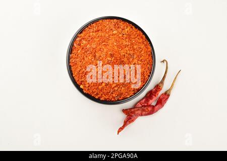 Gemahlenes Chilipulver mit trockenem Cayennechilli, isoliert auf weißem Hintergrund Stockfoto