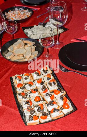 Teller mit kalten Vorspeisen, bestehend aus Häppchen mit Käse, Oliven, Kirschtomaten, Garnelen Stockfoto