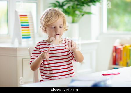 Schulkind macht Hausaufgaben. Online-Fernunterricht von zu Hause aus. Kinder mit Computer, die Videokonferenzen mit Lehrern und Gruppen veranstalten. Stockfoto