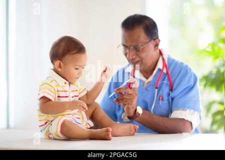 Kinderarzt untersucht Baby. Asiatischer Junge in der Gesundheitsklinik für Test und Screening. Säuglingsimpfung. Kinderbehandlung und Check-up. Stockfoto