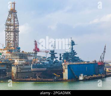 Vom Kreuzfahrtschiff Ruby Princess gesehen, wenn es Galveston verlässt. USS Battleship Texas wird in Galveston Texas repariert. Stockfoto