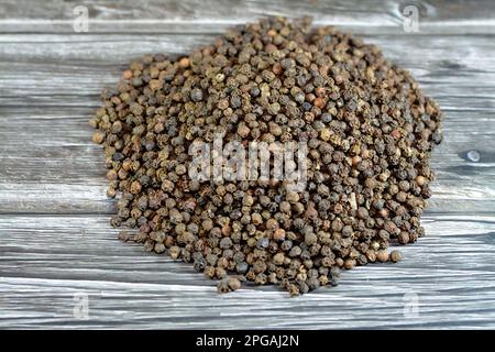 Ein Haufen Pfefferkörner, schwarzer Pfeffer (Piper nigrum), ein blühender Reb der Familie Piperaceae, der für seine Frucht den Pfefferkörner anbaute, getrocknet und verwendet ein Stockfoto