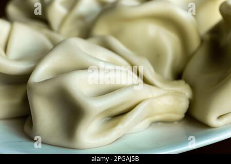 Khinkali, beliebte georgische Teigtaschen aus gedrehten Teigknöpfen, gefüllt mit Fleisch und Gewürzen, eine der nationalen Gerichte Georgiens, aus nächster Nähe. Stockfoto