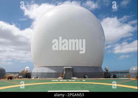 Die Raketenabwehr-Agentur (MDA) veranstaltete am 2. März 2023 auf der Joint Base Pearl Harbor-Hickam, Hawaii, eine Tour des Sea-based X-Band Radar (SBX) auf Ford Island. Mitglieder der lokalen Medien erhielten die Gelegenheit, den SBX-1 zu besichtigen, der bei den Einheimischen als riesiger „Golfball“ bekannt ist. Nach einem Rekord von 662 Tagen auf See wird der SBX-1 regelmäßig gewartet und aktualisiert. Laut MDA ist es das weltweit größte und leistungsstärkste mobile Radar seiner Art. (USA Navy Foto von Joanne Tumacder) Stockfoto