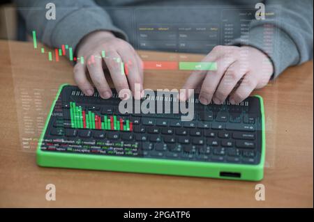 Der Blinde benutzt einen Computer mit einem Braille-Display und einer Computertastatur. HUD-Menü. Aktiendiagramme. Broker-Terminal. Integratives Gerät. Stockfoto